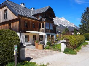 a large wooden house with a mountain in the background at Der grimmige Berg in Sankt Martin am Grimming