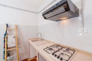 uma cozinha com um fogão e um micro-ondas em Villa Odetta - appartamento Anfora em Torre Colimena