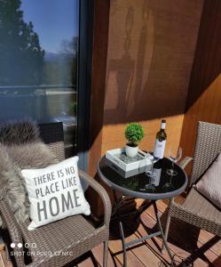 a patio table with a bottle of wine and a pillow at Armeria Residence Snow in Vysoke Tatry - Strbske Pleso