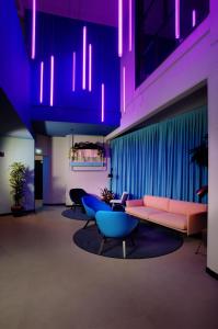 a living room with a couch and chairs and purple lighting at Stay Hotel in Brunello