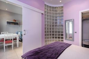 a bedroom with a bed and a wall of wine bottles at Hauzify I Apartament Subirats in Sant Feliu de Guíxols