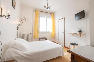 Juvigny-sous-AndaineにあるAu Bon Accueilの白いベッドルーム(白いベッド1台、窓付)