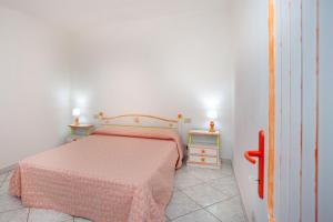 a bedroom with a bed with a pink blanket at Villa Mula 4 in Orosei