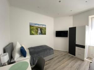a white room with a bed and a tv at Prime Host Smart Apartments in Karlsruhe