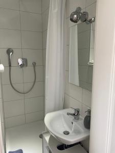 a white bathroom with a sink and a shower at Prime Host Smart Apartments in Karlsruhe