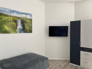 1 dormitorio con 1 cama y TV de pantalla plana en Prime Host Smart Apartments en Karlsruhe