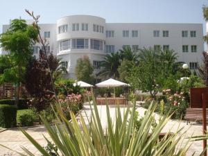 un gran edificio blanco con sombrillas en un jardín en Hotel-Restaurante Jardines La Tejera, en Olula del Río