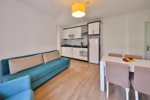 a living room with a blue couch and a table at Bossa Nova Apart Hotel in Kaş