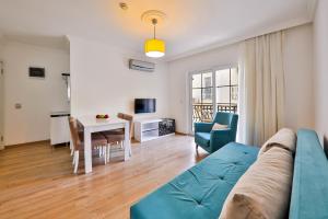 a living room with a blue couch and a table at Bossa Nova Apart Hotel in Kaş