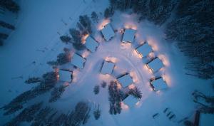 an aerial view of a group of buildings in the snow at night at Hotel Björnson Jasná & Björnson TREE HOUSES in Belá