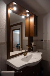 ein Badezimmer mit einem Waschbecken und einem großen Spiegel in der Unterkunft Petit Paradis in Valgrisenche