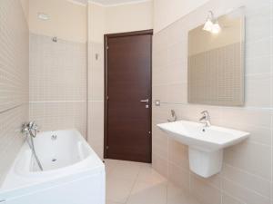 un bagno con un lavandino, una vasca e uno specchio di Casa Salsa Libre a Selargius Altre 20 foto