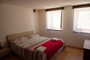 Un dormitorio con una cama con sábanas rojas y una ventana en Petit Paradis en Valgrisenche