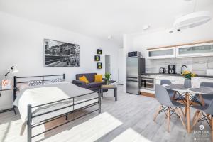 ein Schlafzimmer mit Bett und ein Wohnzimmer in der Unterkunft Pearl Apartments Rogowo by Jantar Apartamenty Kołobrzeg in Rogowo