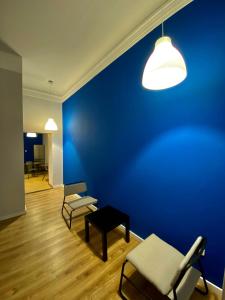 Habitación con pared azul, sillas y mesa. en SKY HOSTEL en Cracovia