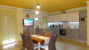 une cuisine avec une table et des chaises ainsi qu'une télévision dans l'établissement Gere Apartment House, à Harkány