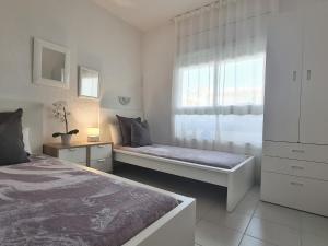 une chambre blanche avec un lit et une fenêtre dans l'établissement Apartamentos Mar D'Or, à L'Estartit 165 autres photos