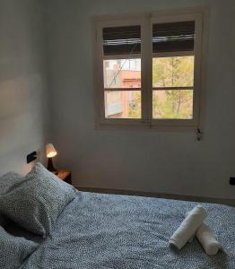 Schlafzimmer mit einem Bett und einem Fenster in der Unterkunft Wanderlust Apartment Old Town in Tarragona
