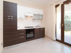 una cucina con armadi marroni e piano cottura di Casa Salsa Libre a Selargius
