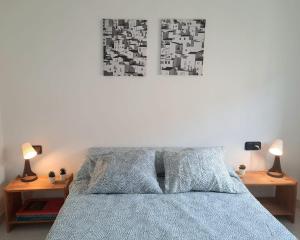 a bedroom with a bed with two lamps on tables at Wanderlust Apartment Old Town in Tarragona