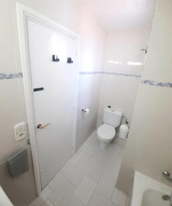 a white bathroom with a toilet and a shower at Wanderlust Apartment Old Town in Tarragona