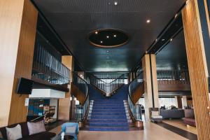 una escalera de caracol en un edificio con alfombra azul en Rua Rasada Hotel - The Ideal Venue for Meetings & Events en Trang