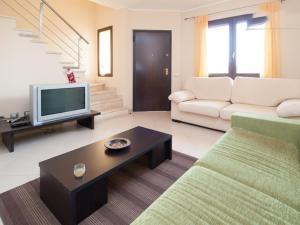 un soggiorno con un divano e una TV di Casa Salsa Libre a Selargius