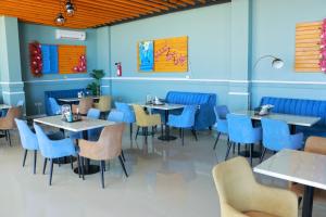 un restaurante con paredes azules, mesas y sillas en ALmansor furnished Apartment 1 en Salalah