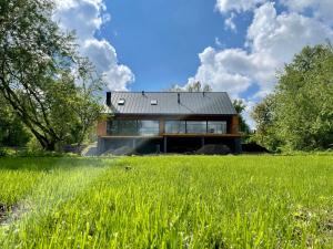 哥尼亞茲的住宿－Stodoła nad Biebrzą，一座黑屋顶和绿地的房子