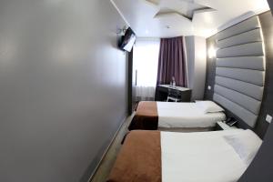 a bedroom with a bed and a dresser at Hotel Phenix in Brussels