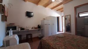 a bedroom with a bed and a desk and a refrigerator at Casa Vacanza e Camera Fabiola in Castellammare del Golfo