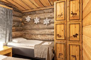 a bedroom with a bed in a log cabin at Polar Aurora Cabins in Saariselka
