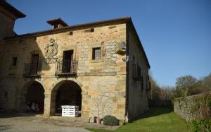 Entrambasaguas的住宿－Impresionante Caserío Montañes del Siglo XVII，一座古老的石头建筑,在院子里设有拱门