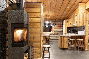 a living room with a fireplace in a log house at Polar Aurora Cabins in Saariselka