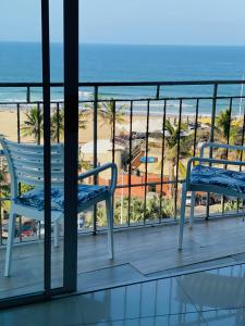 a balcony with two chairs and a view of the beach at 66Windemere self catering apartments in Durban