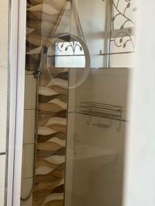 a glass shower in a bathroom with a wooden floor at 66Windemere self catering apartments in Durban