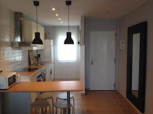 a kitchen with a counter and some stools in it at Hacienda Golf Ático Islantilla in Islantilla