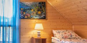a room with a bed and a painting on the wall at Słonecznikowe Wzgórze in Debina