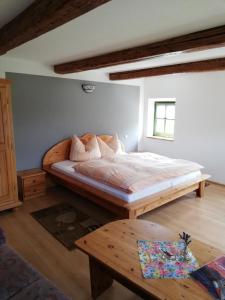 1 dormitorio con cama grande y mesa de madera en Lichtenhainer Hof, en Lichtenhain