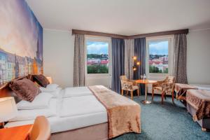 プラハにあるPlaza Prague Hotel - Czech Leading Hotelsのベッド、テーブル、椅子が備わるホテルルームです。