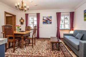 ein Wohnzimmer mit einem Tisch und einem blauen Sofa in der Unterkunft Stammhaus - Premium Residences in Rauris