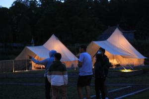 a group of people standing in a field with tents at Tampurhyangview in Kintamani