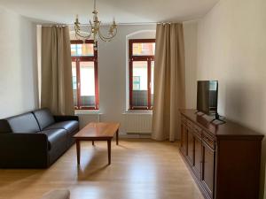 a living room with a couch and a tv at Apartments SMAG Barbiergasse in Pirna