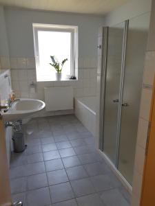 a bathroom with a tub and a sink and a shower at Ferienhaus 7a in Munster im Heidekreis