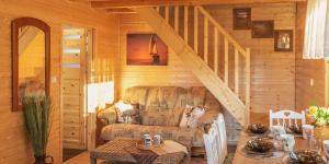 a living room with a couch and a staircase at Słonecznikowe Wzgórze in Debina