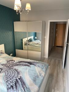 a bedroom with a bed with a large mirror at Nowoczesny apartament Gdańsk Spektrum blisko morza in Gdańsk