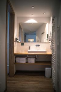 a bathroom with a sink and a large mirror at Pension Yvonne - SUPERIOR in Rust