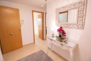 Cette chambre comprend une table avec un miroir et des fleurs. dans l'établissement Apartamento Romero Valencia, à Benicull