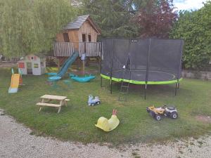 a playground with a trampoline and some toys in the grass at Gîte Les Mariniers - 3 étoiles in Mareuil-sur-Cher