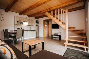 a living room with a staircase and a kitchen at Domki Pokoje Fil in Solina